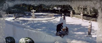 Movie still from “Nicholas and Alexandra” (1971), directed by Franklin J. Schaffner – A man kneeling down in the snow next to a fountain; Extreme Wide shot, High angle