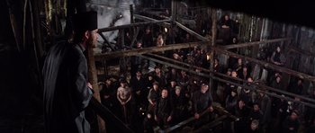 Movie still from “Nicholas and Alexandra” (1971), directed by Franklin J. Schaffner – A group of men sitting on top of a pile of wood; Wide shot, High angle