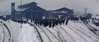 Movie still from “Nicholas and Alexandra” (1971), directed by Franklin J. Schaffner – A group of people walking across a snow covered train track; Extreme Wide shot, High angle