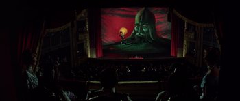 Movie still from “Nicholas and Alexandra” (1971), directed by Franklin J. Schaffner – A man is standing on a stage in front of a giant picture; Extreme Wide shot, Low angle