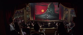 Movie still from “Nicholas and Alexandra” (1971), directed by Franklin J. Schaffner – A large crowd of people watching a man on a giant screen; Extreme Wide shot, High angle