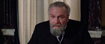 Movie still from “Nicholas and Alexandra” (1971), directed by Franklin J. Schaffner – An older man with a beard and a mustache wearing a black suit; Close Up shot, Low angle