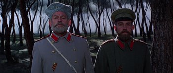 Movie still from “Nicholas and Alexandra” (1971), directed by Franklin J. Schaffner – Two men dressed in military uniforms standing next to each other in front of trees; Medium shot, Low angle