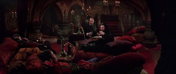 Movie still from “Nicholas and Alexandra” (1971), directed by Franklin J. Schaffner – A group of people sitting on a couch eating food; Wide shot, High angle