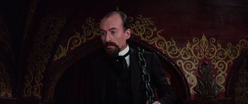 Movie still from “Nicholas and Alexandra” (1971), directed by Franklin J. Schaffner – A man with a beard and a chain around his neck; Medium shot, Low angle