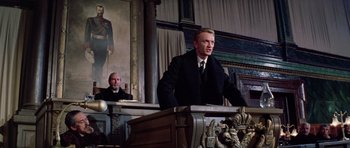 Movie still from “Nicholas and Alexandra” (1971), directed by Franklin J. Schaffner – A man in a suit and tie standing in front of a podium; Medium shot, Low angle