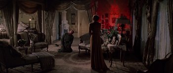 Movie still from “Nicholas and Alexandra” (1971), directed by Franklin J. Schaffner – A man kneeling down in front of a woman in a living room; Wide shot, High angle