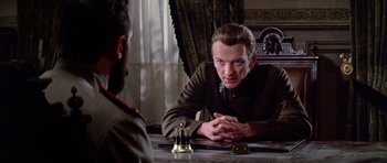 Movie still from “Nicholas and Alexandra” (1971), directed by Franklin J. Schaffner – A man sitting in front of a mirror talking to another man; Medium shot, Over the shoulder angle