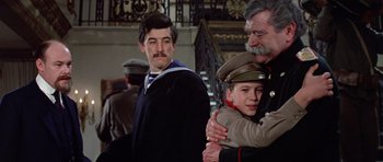 Movie still from “Nicholas and Alexandra” (1971), directed by Franklin J. Schaffner – Two men and a boy in military garb are hugging each other; Medium shot, Low angle