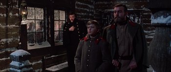 Movie still from “Nicholas and Alexandra” (1971), directed by Franklin J. Schaffner – A man and a boy in military uniforms standing next to each other in front of a brick building; Medium shot, Low angle
