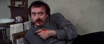 Movie still from “Nicholas and Alexandra” (1971), directed by Franklin J. Schaffner – A man with blood on his face eating a stick; Close Up shot, High angle