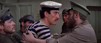 Movie still from “Nicholas and Alexandra” (1971), directed by Franklin J. Schaffner – A man wearing a sailor's hat and a striped shirt; Close Up shot, Over the shoulder angle