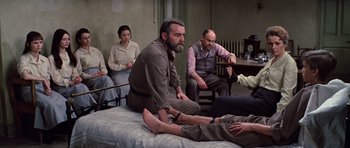 Movie still from “Nicholas and Alexandra” (1971), directed by Franklin J. Schaffner – A group of people sitting on top of a bed in a room; Wide shot, High angle