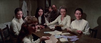 Movie still from “Nicholas and Alexandra” (1971), directed by Franklin J. Schaffner – A group of people sitting around a table with papers; Medium shot, High angle