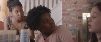 Movie still from “Night Comes On” (2018), directed by Jordana Spiro – A woman sitting in front of a brick wall; Close Up shot, Over the shoulder angle