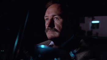 Movie still from “Night Moves” (1975), directed by Arthur Penn – A person wearing a suit and tie; Close Up shot, Low angle