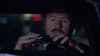Movie still from “Night Moves” (1975), directed by Arthur Penn – A person driving a car at night; Close Up shot, Low angle