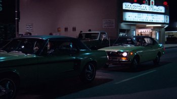 Movie still from “Night Moves” (1975), directed by Arthur Penn – A group of cars driving down a street at night; Wide shot, Low angle