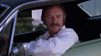 Movie still from “Night Moves” (1975), directed by Arthur Penn – A man sitting in the driver's seat of a car; Close Up shot, Low angle