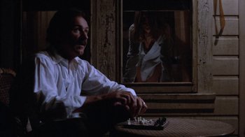 Movie still from “Night Moves” (1975), directed by Arthur Penn – A man sitting in front of a woman in a white shirt; Medium shot, Low angle