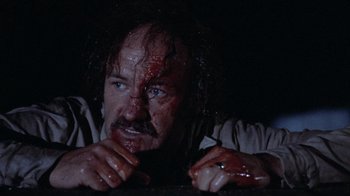 Movie still from “Night Moves” (1975), directed by Arthur Penn – A man with blood all over his face and neck; Close Up shot, Low angle