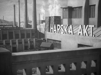 Movie still from “Night Train to Munich” (1940), directed by Carol Reed – An old photo of a building with a factory in the background; Extreme Wide shot, Low angle