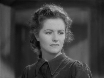 Movie still from “Night Train to Munich” (1940), directed by Carol Reed – An old photo of a woman in a black shirt; Close Up shot, High angle