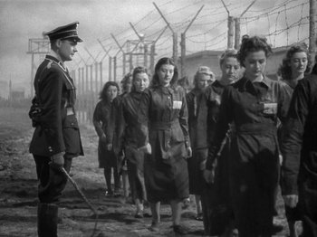 Movie still from “Night Train to Munich” (1940), directed by Carol Reed – A group of women are standing next to each other in a field; Wide shot, Low angle