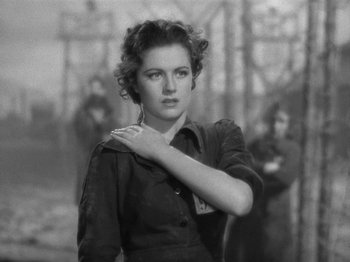 Movie still from “Night Train to Munich” (1940), directed by Carol Reed – An old black and white photo of a woman with her hand on her shoulder; Close Up shot, Low angle