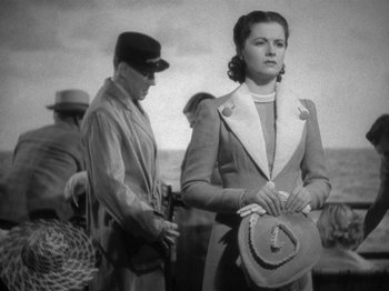 Movie still from “Night Train to Munich” (1940), directed by Carol Reed – An old black and white photo of a man and a woman; Medium shot, Low angle