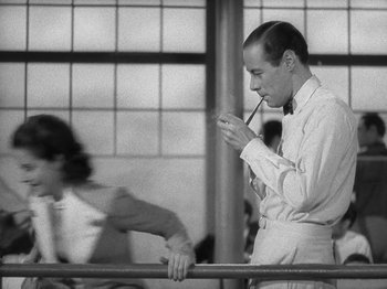 Movie still from “Night Train to Munich” (1940), directed by Carol Reed – A black and white photo of a man smoking a pipe; Medium shot, Low angle
