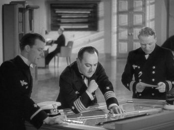 Movie still from “Night Train to Munich” (1940), directed by Carol Reed – A group of men sitting at a table in a room; Medium shot, High angle