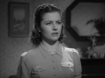 Movie still from “Night Train to Munich” (1940), directed by Carol Reed – A black - and - white photo of a woman in a dress; Close Up shot, Low angle
