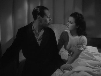 Movie still from “Night Train to Munich” (1940), directed by Carol Reed – A black and white photo of a man and a woman; Medium shot, High angle