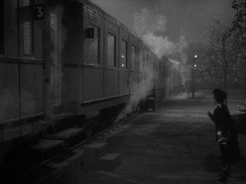 Movie still from “Night Train to Munich” (1940), directed by Carol Reed – A black and white photo of a train on a train track; Wide shot, High angle