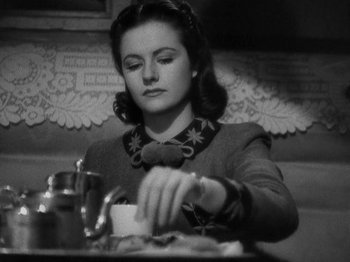 Movie still from “Night Train to Munich” (1940), directed by Carol Reed – A woman sitting at a table with a plate of food; Close Up shot, High angle
