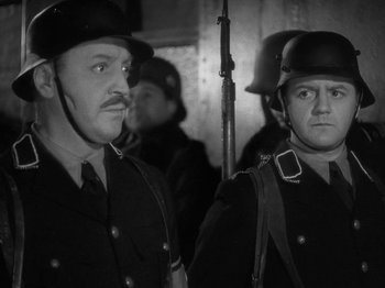 Movie still from “Night Train to Munich” (1940), directed by Carol Reed – A black and white photo of two men in uniform; Close Up shot, Low angle