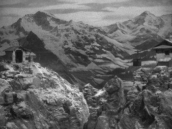 Movie still from “Night Train to Munich” (1940), directed by Carol Reed – A black and white photo of a mountain range; Extreme Wide shot, High angle