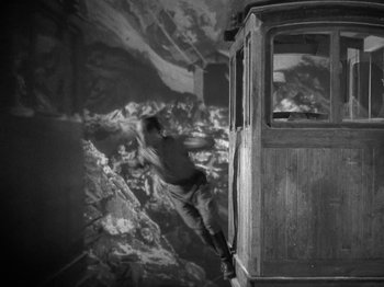 Movie still from “Night Train to Munich” (1940), directed by Carol Reed – A man jumping off of a train into the air; Wide shot, High angle