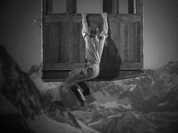 Movie still from “Night Train to Munich” (1940), directed by Carol Reed – A man hanging upside down on a skateboard; Wide shot, Low angle