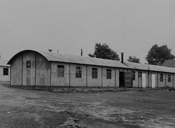 Movie still from “Night and Fog” (1956), directed by Alain Resnais – An old building with a lot of windows on the outside; Extreme Wide shot, Low angle