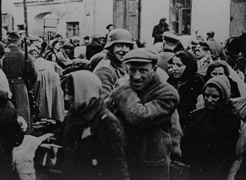Movie still from “Night and Fog” (1956), directed by Alain Resnais – A group of people gathered together in a crowd; Medium shot, High angle