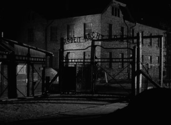 Movie still from “Night and Fog” (1956), directed by Alain Resnais – A black and white photo of an old building; Extreme Wide shot, High angle