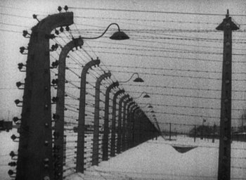 Movie still from “Night and Fog” (1956), directed by Alain Resnais – A black and white photo of a barbed wire fence; Extreme Wide shot, Low angle