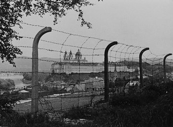 Movie still from “Night and Fog” (1956), directed by Alain Resnais – A black and white photo of a barbed wire fence; Extreme Wide shot, Low angle