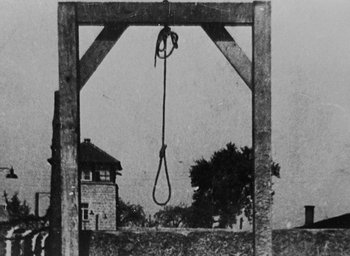 Movie still from “Night and Fog” (1956), directed by Alain Resnais – An old photo of a gallows with a rope hanging from it; Extreme Wide shot, Low angle