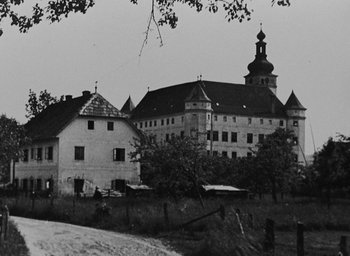 Movie still from “Night and Fog” (1956), directed by Alain Resnais – A black and white photo of a large building; Extreme Wide shot, Low angle