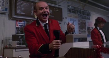 Movie still from “Night of the Comet” (1984), directed by Thom Eberhardt – A man in a red jacket is holding a microphone; Medium shot, Low angle