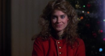 Movie still from “Night of the Comet” (1984), directed by Thom Eberhardt – A woman in a red jacket smiling for the camera; Close Up shot, Over the shoulder angle