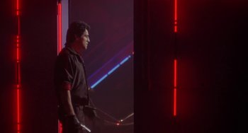 Movie still from “Night of the Comet” (1984), directed by Thom Eberhardt – A man standing in front of a wall with red lighting; Medium shot, Low angle